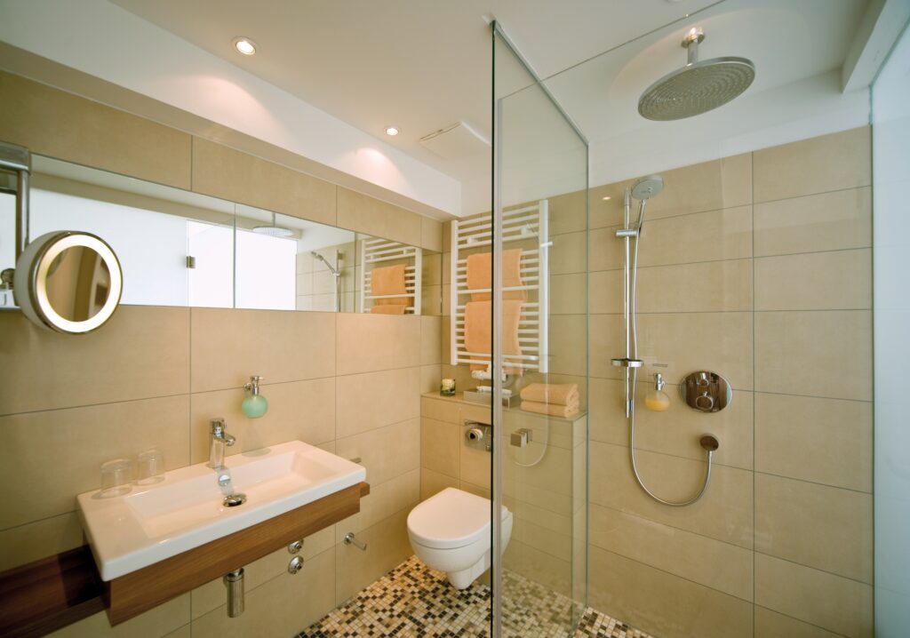 Badezimmer Komfort mit Blick auf Waschbecken und Dusche mit Glaswand