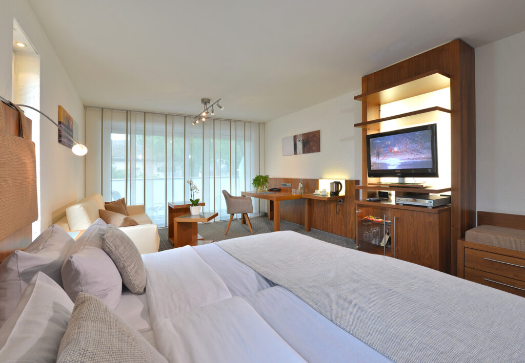 Deluxezimmer Parkhotel Oberhausen. Blick aufs Bett seitlich , TV Wand und Fensterfront