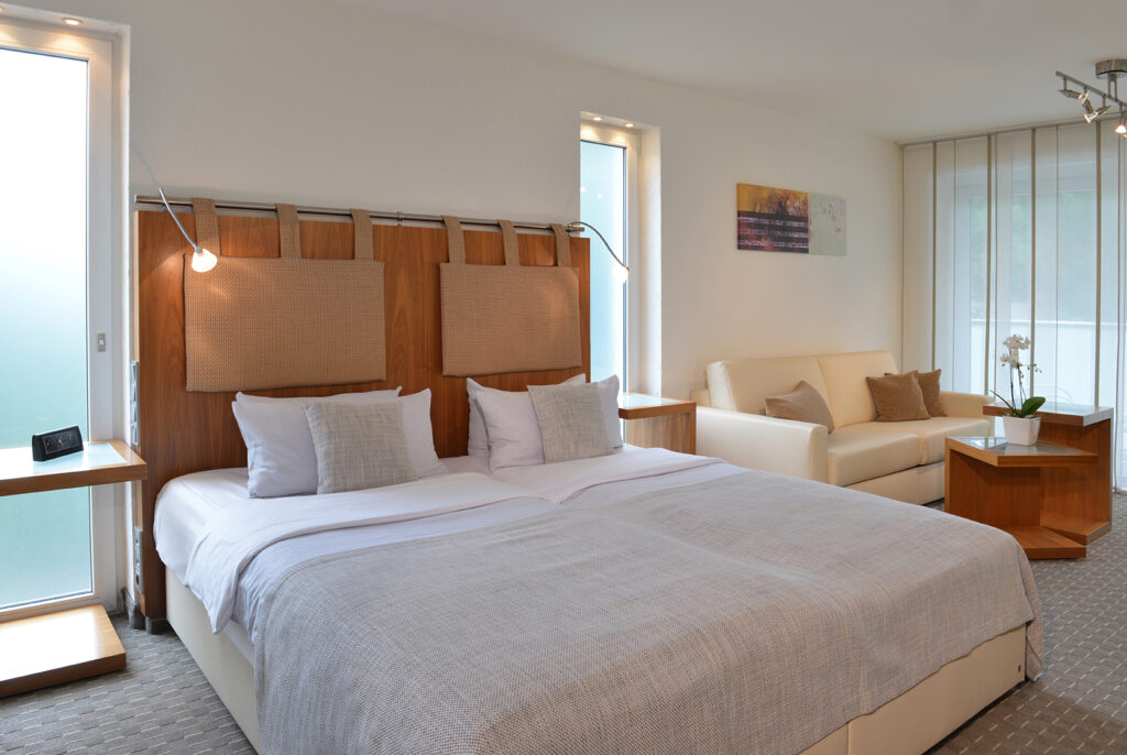 Deluxezimmer Parkhotel Oberhausen Blick auf das Bett in beige und hellgrau gehalten