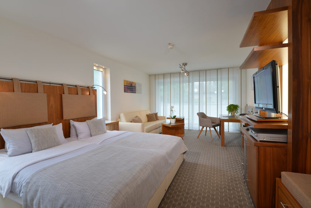 Deluxezimmer Parkhotel Oberhausen Blick auf das ganze Zimmer mit Bett, Schreibtischwand und Sitzecke