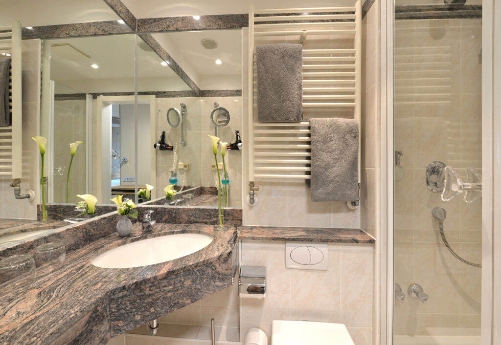 Badezimmer Standardzimmer im Parkhotel Oberhausen mit Blick auf Waschbecken, Handtuchhalter an der Wand. in grau wei&szlig; gehalten