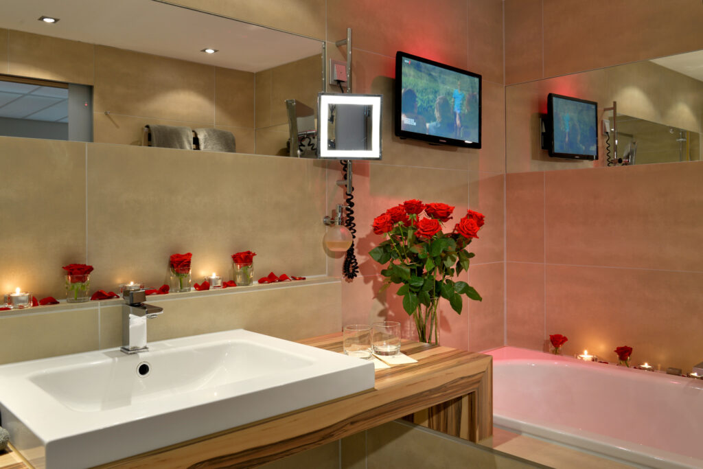 Badezimmer Juniorsuite Ansicht auf Waschbecken dekoriert mit roten Rosen romantisch